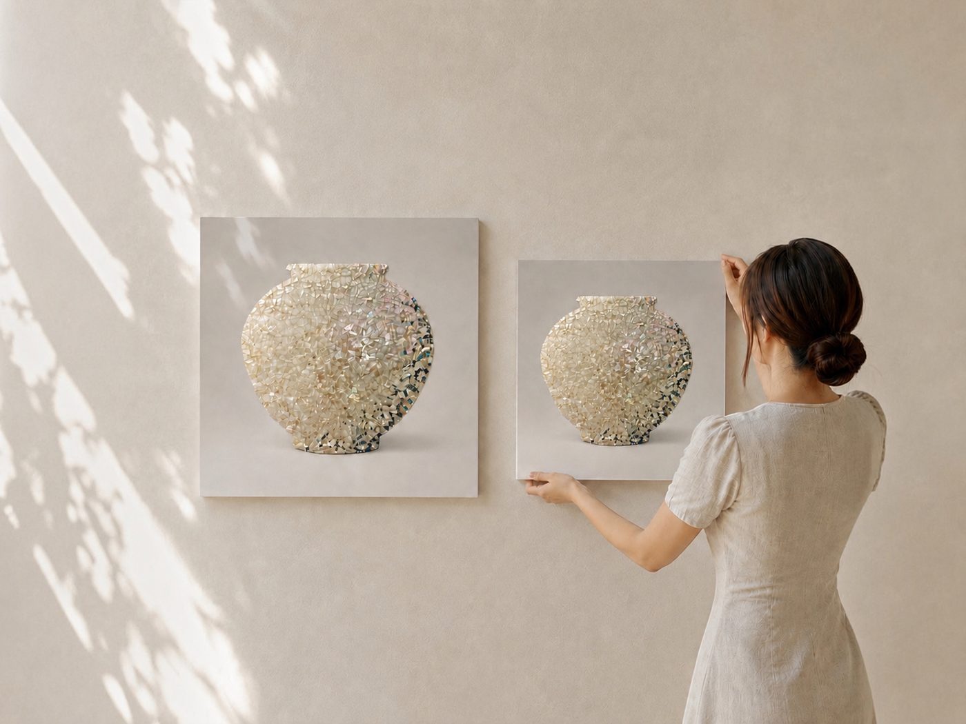完成した48cm（左）と36cm（右）の月壺アートを、女性が壁に飾っている様子